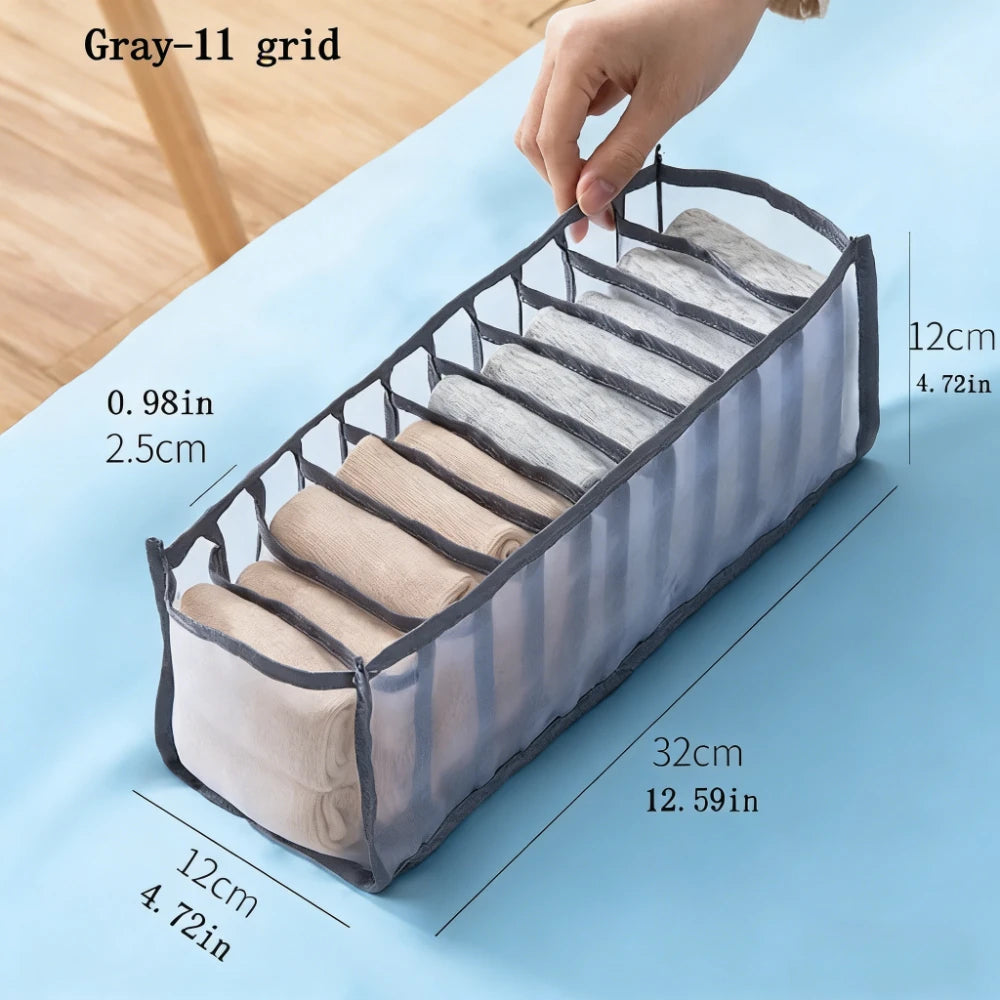 Gray grid foldable drawer organizer for undergarments and accessories shown on a light blue surface.