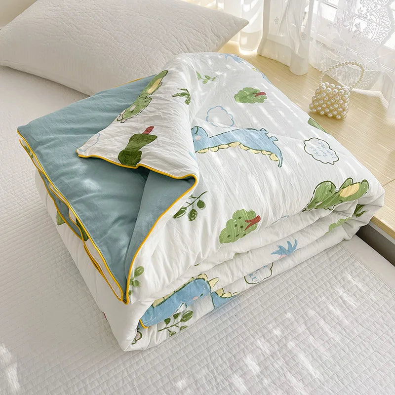 A white quilt with a light blue background featuring illustrations of green leaves and clouds.