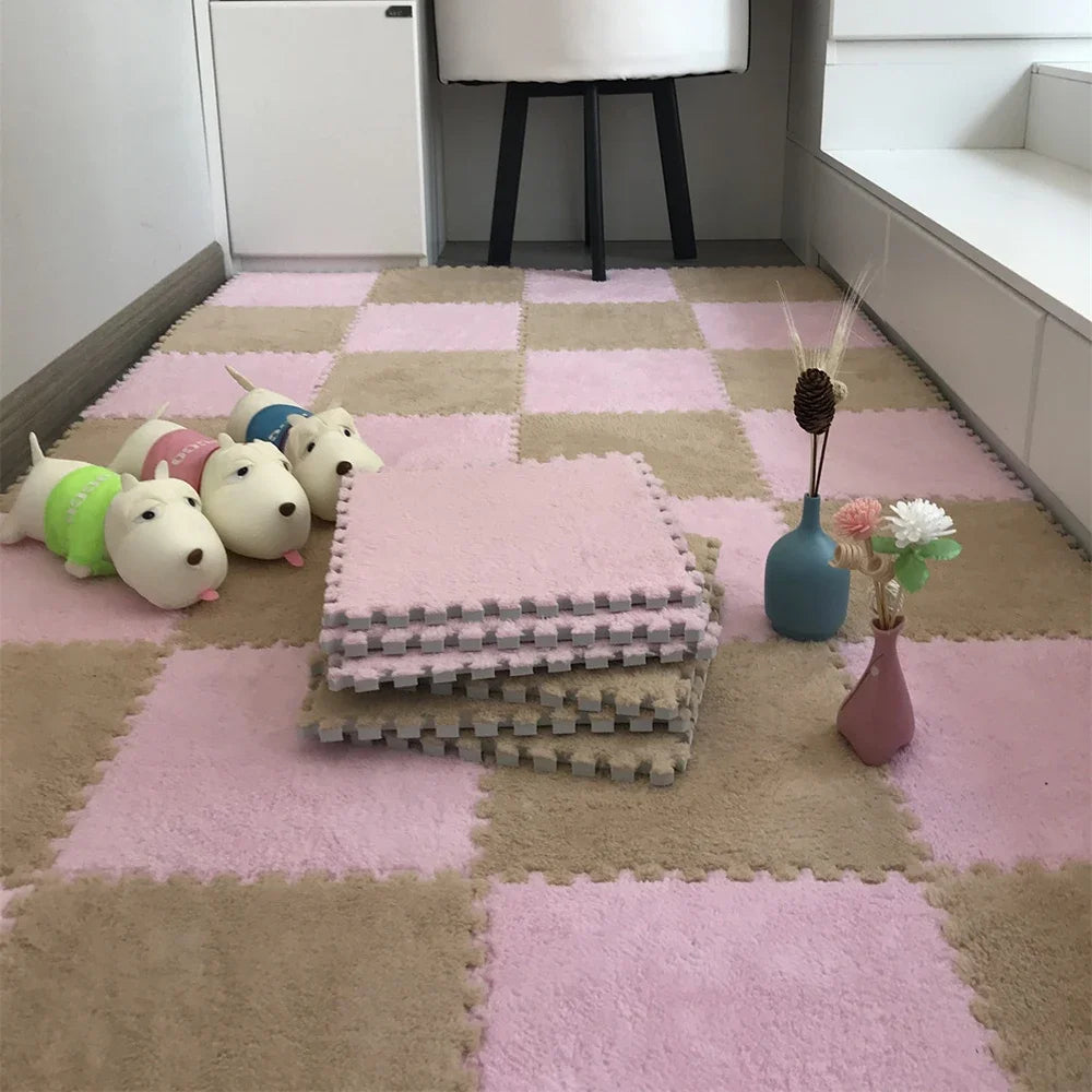 A pink and beige checkered play mat with several stacked white plush toys on the surface.