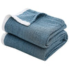A folded blue muslin throw blanket with white trim.