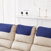 Three navy blue quilted headrest protector covers on a beige recliner sofa.