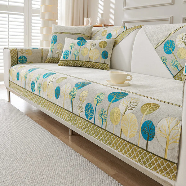 A light beige jacquard sofa seat and back cover featuring a pattern of blue and yellow tree silhouettes.