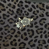 Silver star-shaped pocket watch keychain with an adjustable clock face set against a leopard print fabric background