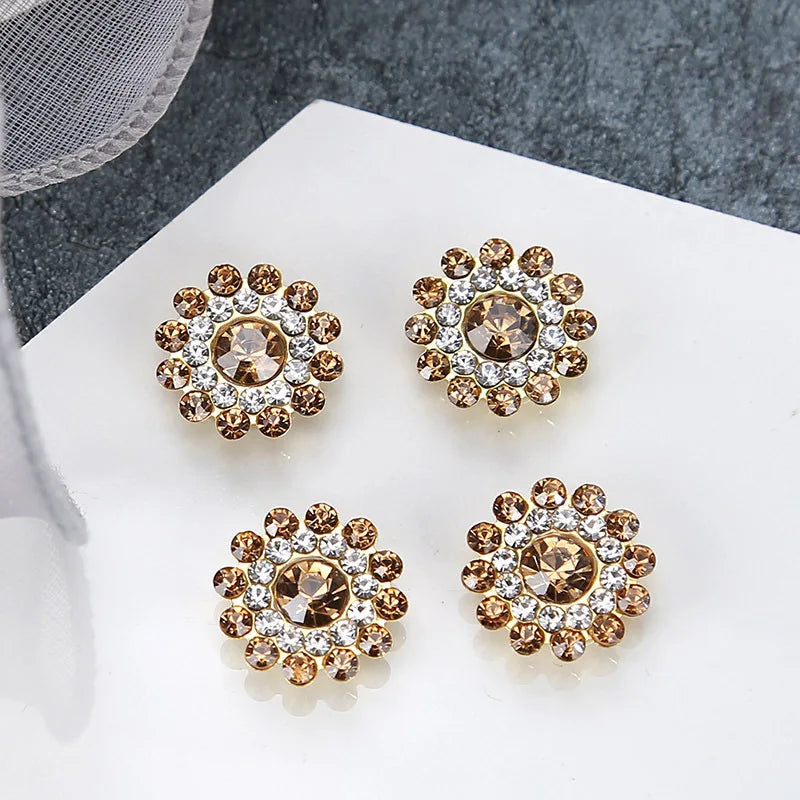 Four clusters of multicolor sew-on rhinestone crystals with gold and clear stones displayed on a white surface.