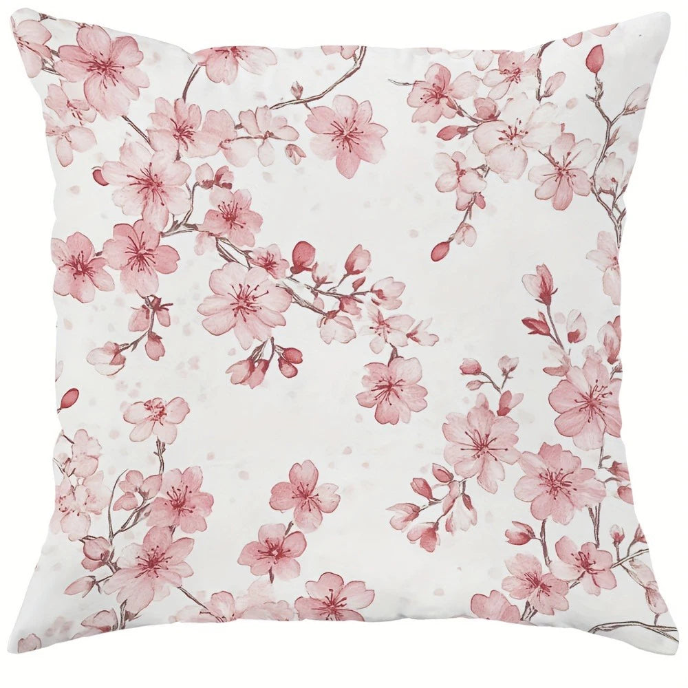 A decorative pillow cover featuring a watercolor pattern of pink cherry blossoms on a white background.