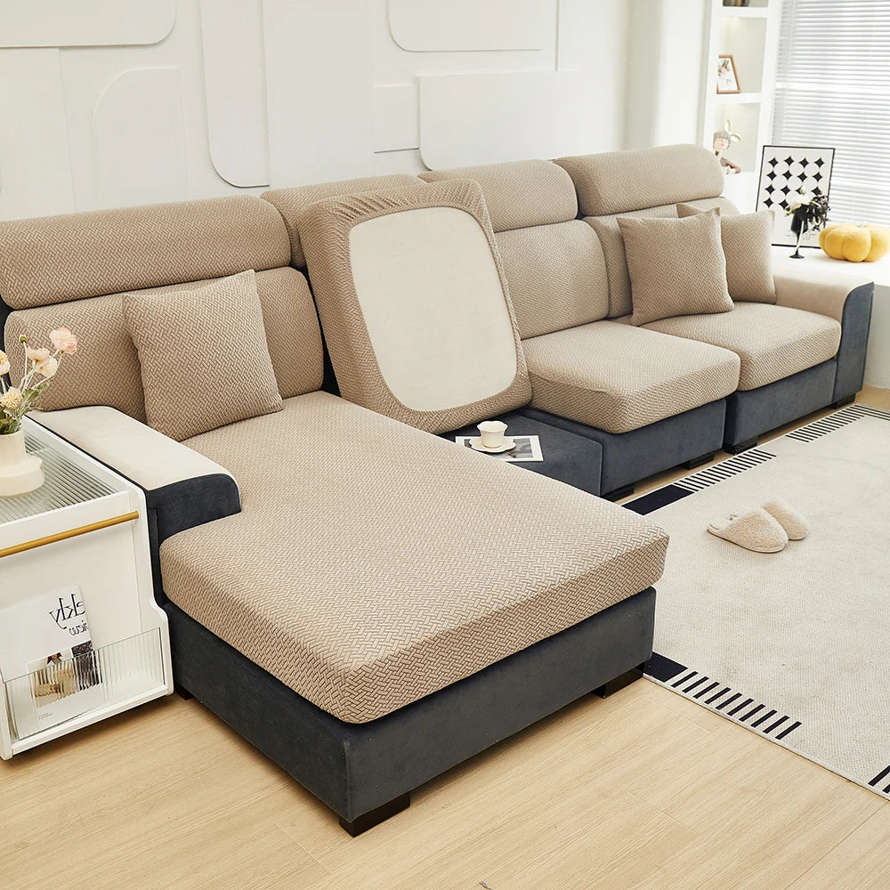 A beige jacquard elastic sofa slipcover featuring a modern sectional design in a light neutral tone.