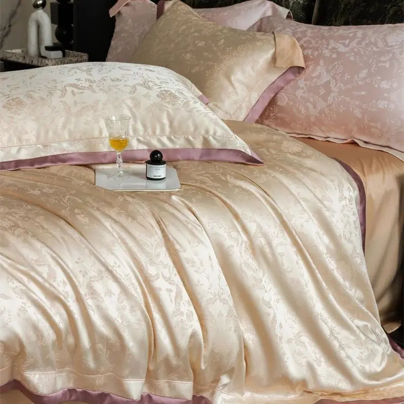 A luxurious bedding set featuring pale pink and beige satin fabric with floral patterns.