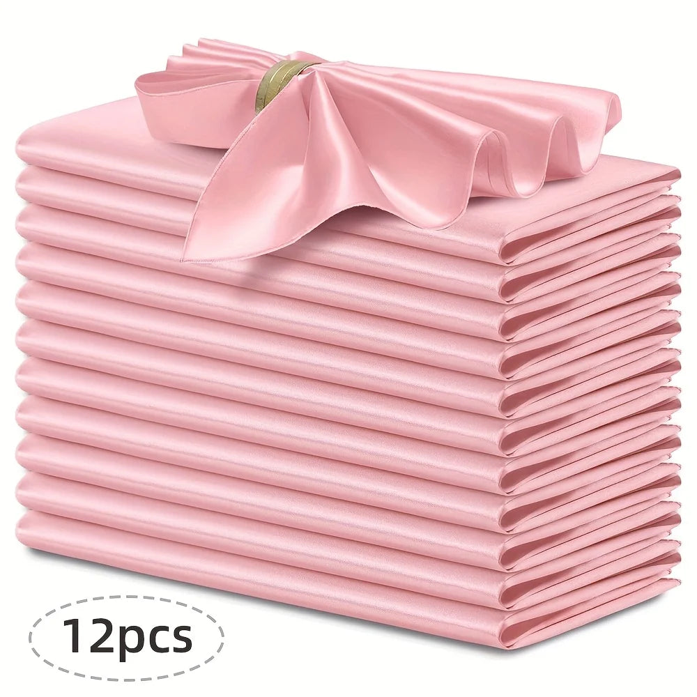 A stack of twelve pink silky satin dinner napkins with a decorative bow on top.
