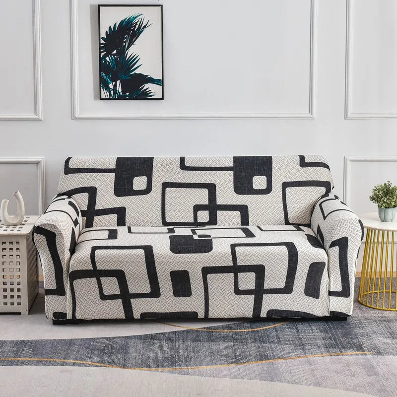 A modern sofa covered in a black and white geometric pattern displayed against a light gray wall.