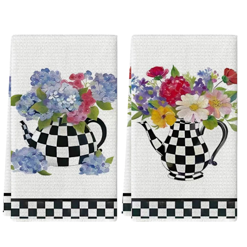 A set of two black and white checkered kitchen towels featuring colorful floral designs.