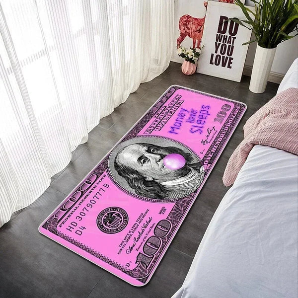 Pink decorative floor mat featuring a US hundred dollar bill design placed on a bedroom floor.