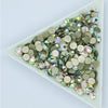 A collection of flatback crystal rhinestones in various shades of green and clear, sparkling accents.