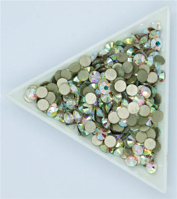 A collection of flatback crystal rhinestones in various shades of green and clear, sparkling accents.