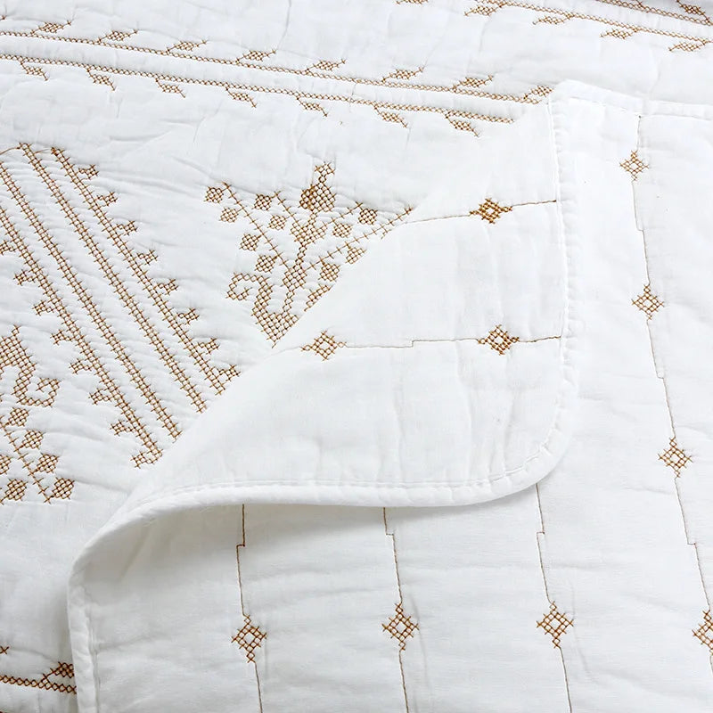 White Nordic cotton bedding featuring delicate brown embroidery patterns.