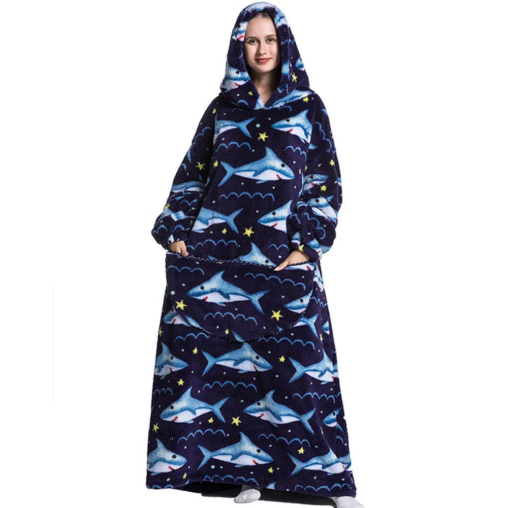 A woman wearing a navy blue patterned sherpa fleece oversized blanket hoodie with a hood and front pockets.