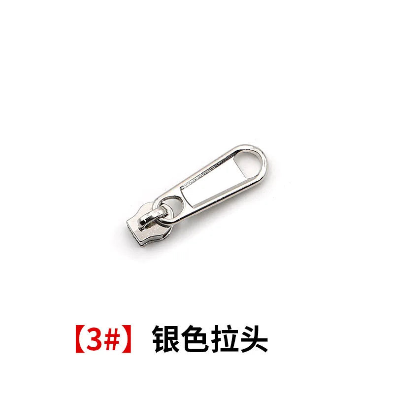 A silver metal zipper pull or slider component.