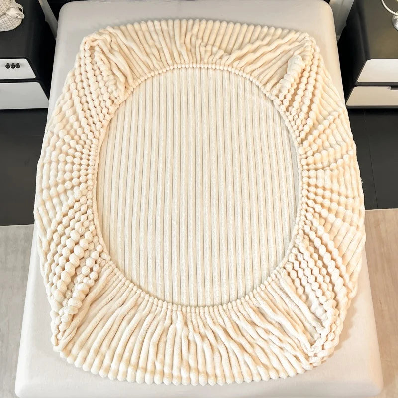 A round, cream-colored knitted item resembling a wreath or oval frame, likely a decorative textile.