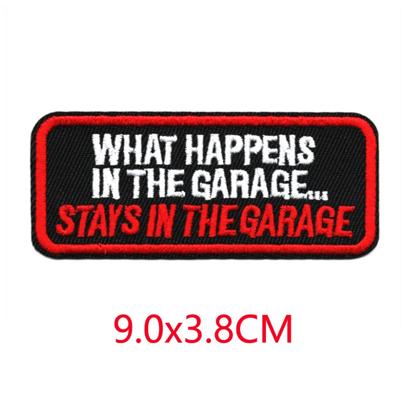 Black embroidered patch with red text that reads What Happens In The Garage Stays In The Garage