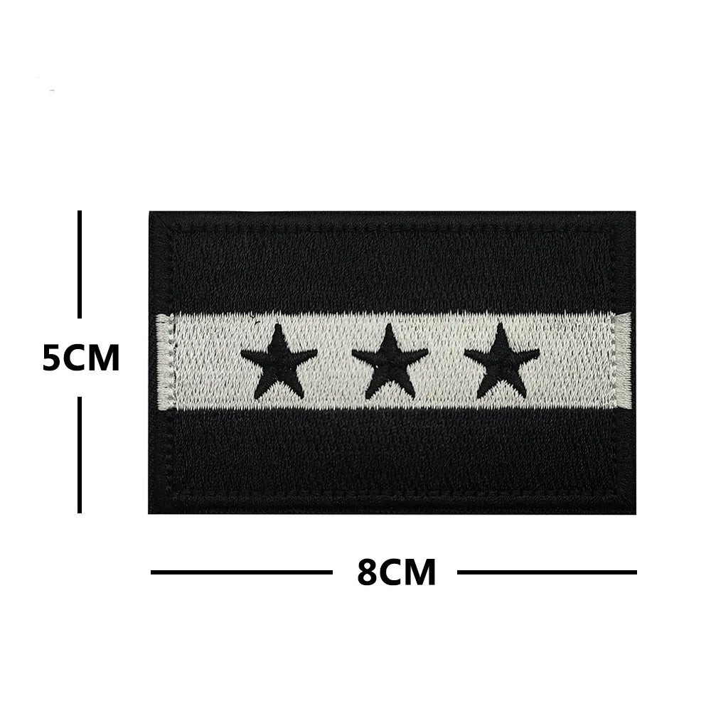 Black and white embroidered patch featuring three stars on a black background.