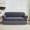 A charcoal gray anti-slip jacquard sofa slipcover displayed on a white wooden shelf.