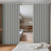 Heavy duty foldable room divider curtain in light gray fabric shown partially open in a modern interior.