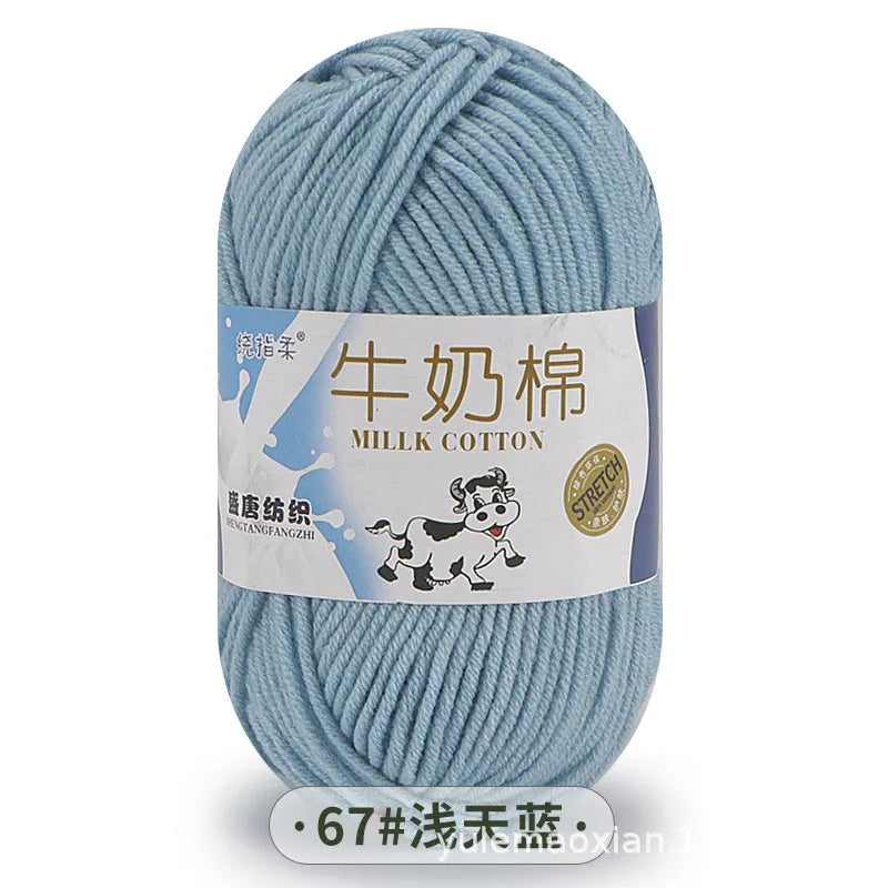 A ball of light blue milk cotton yarn with a label in Chinese and English.