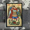 A embroidered patch depicting the Archangel Michael with wings, holding a hook, and a serpent below.
