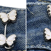 Silver butterfly button clips attached to denim fabric for clothing adjustment