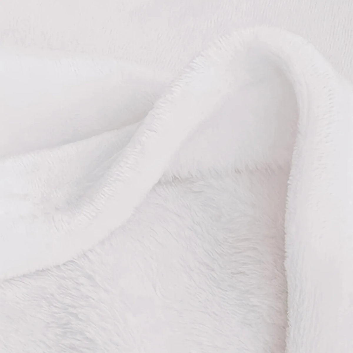 A close-up of a white vintage floral patchwork throw blanket draped softly.