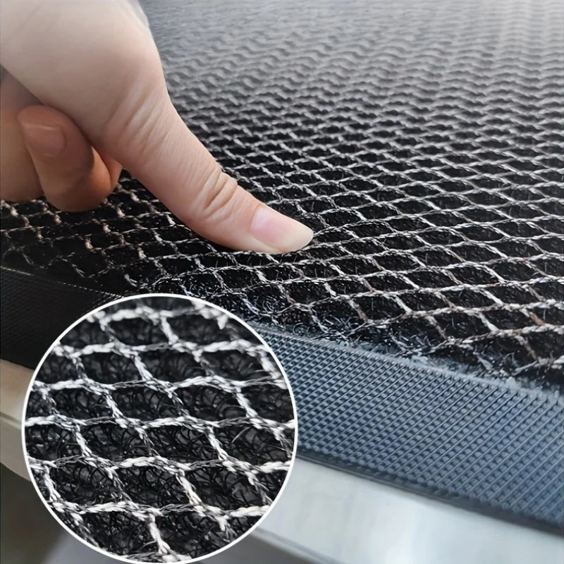 Close-up view of a black non-slip rubber doormat texture with a hand touching the surface.