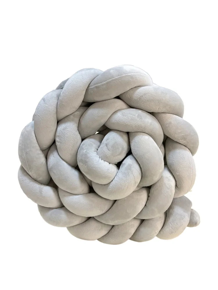 A round, light gray handmade knotted floor mat for bed decor.