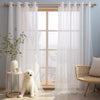 White sheer tulle window curtains hanging in a light-colored room with a white dog and wooden window frame